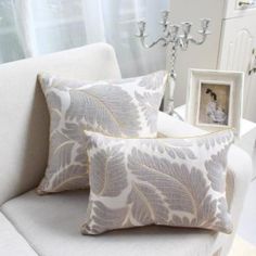 two decorative pillows on a white couch