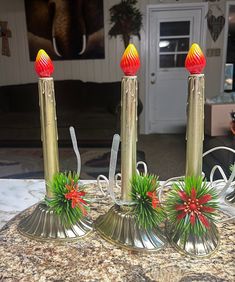 three candles with red and yellow decorations on them