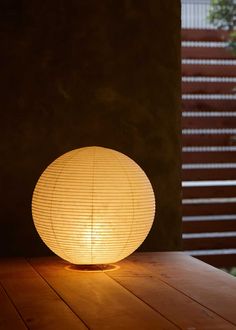 a round lamp sitting on top of a wooden table