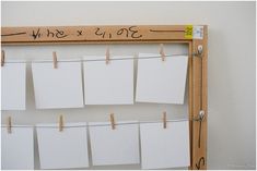 a bulletin board with notes pinned to clothes pins