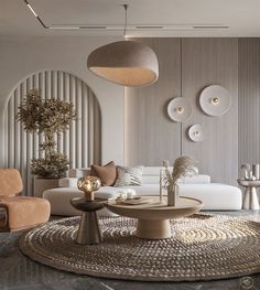 a living room with white couches and large round table in front of the wall