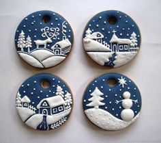 four decorated cookies are sitting on a table