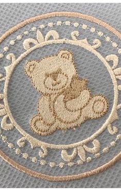 a teddy bear embroidered onto a gray background