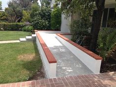 an outdoor patio with brick steps leading up to the back door and side yard area