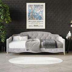 a white couch sitting in front of a black wall next to a potted plant