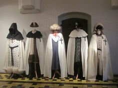 five mannequins dressed in white and black robes