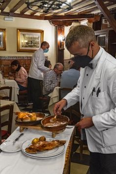 a man in a white jacket is serving food