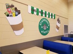 there is a starbucks sign hanging on the wall in this school cafeteria room with blue booths