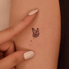 a woman's arm with a small butterfly tattoo on the left side of her body