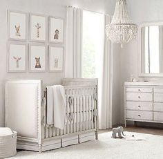 a baby's room with white furniture and pictures on the wall