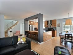 a living room filled with furniture next to a kitchen and dining room table in front of an open floor plan