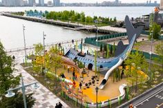 an aerial view of a park with children's play area and water in the background