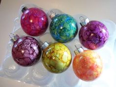 six glass ornaments in different colors on a plate