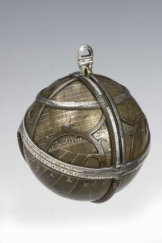 an antique silver globe on display against a white background