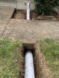 a white fire hydrant sitting next to a hole in the ground