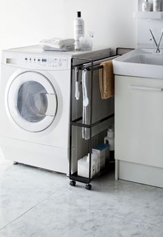 a white washer sitting next to a sink and a dryer in a bathroom