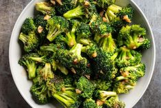 a white bowl filled with broccoli on top of a wooden table