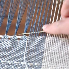 someone is weaving something on a large piece of cloth