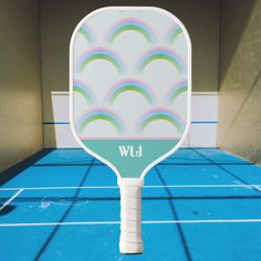 a tennis racket on a blue court with the words wlj printed on it