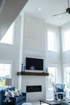 a living room filled with furniture and a flat screen tv mounted on the wall above a fireplace