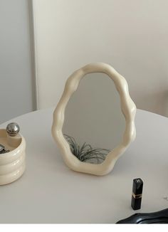 a round mirror sitting on top of a white table