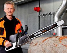 a man in an orange and black jacket holding a chainsaw