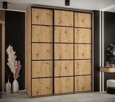 a large wooden cabinet in a room with black walls and wood flooring on the wall