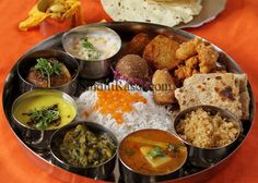 a metal tray filled with different types of food on an orange cloth covered tablecloth