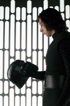 a man in a star wars outfit holding a black helmet