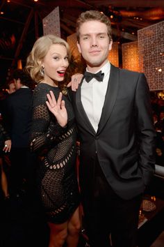 a man in a tuxedo and a woman in a black dress at an event