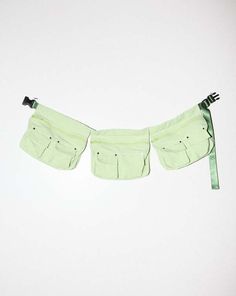 two pieces of green cloth hanging from a clothes line on a white wall with no one in it