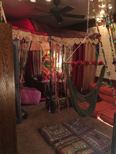 a bed room with a hammock hanging from the ceiling and pillows on the floor