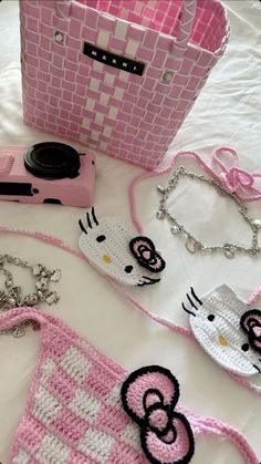 crocheted hello kitty purses and other items on a bed