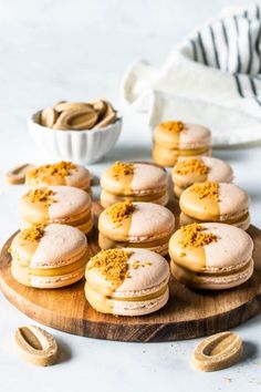 a wooden board topped with mini sandwiches covered in powdered sugar and pistachio