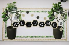 a welcome sign with potted plants on it