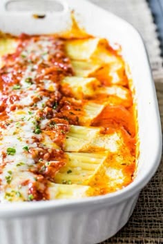 a white casserole dish filled with pasta and sauce