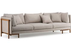 a couch with many pillows on it and some wood frame around the armrests