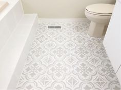 a white toilet sitting next to a bath tub in a bathroom on top of a tiled floor