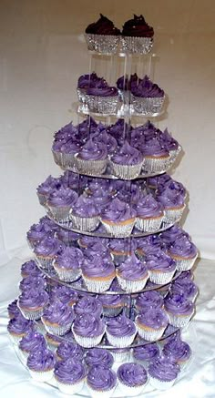 a tower of cupcakes with purple frosting on them