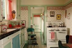 an old fashioned kitchen with green walls and white appliances