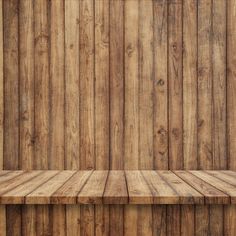 an empty wooden shelf in front of a wood paneled wall with no one on it