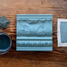 a wooden table topped with blue paint and decorative molding pieces on top of it