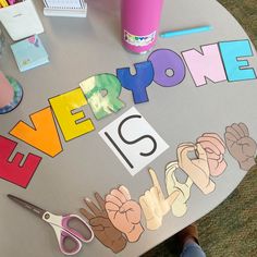 a table topped with cut out letters and scissors