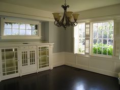 a chandelier hangs from the ceiling in an empty room with wood flooring