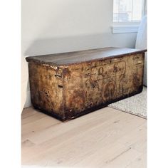 an old trunk sitting on top of a hard wood floor