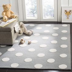 a teddy bear sitting on top of a gray rug