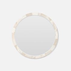 a white circular mirror on a wall with an abstract pattern in the middle and bottom