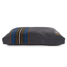 a dog bed with a striped pillow on the front and back side, in grey