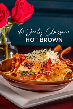 a plate of lasagna with red roses in the background and text overlay that reads, a dirty classic hot brown