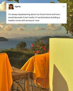 an image of a table and chairs with yellow cloths on the outside, overlooking water